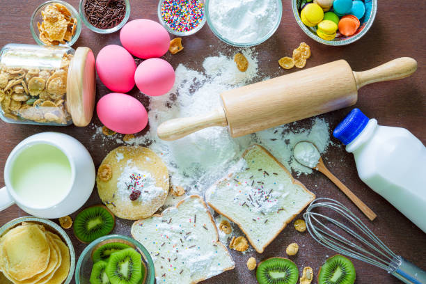 istock Baking background with organic eggs, flour, wheat grains, oatmeals, butter, raisins and rolling pin on dark wooden table. Pastry making and bakery concept, top view, copy space 1257052297