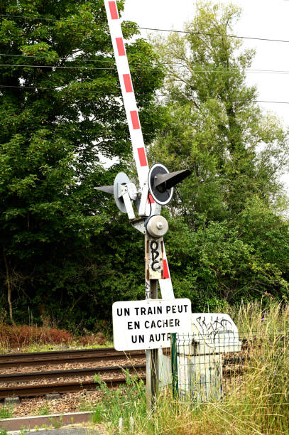 Railroad crossing in the countryside Around Paris, France - june 20 2020 : Railroad crossing in the countryside. Automatic railroad crossing with trees in the background railway signal stock pictures, royalty-free photos & images