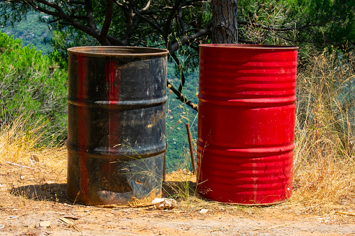 black and red steel barrel on the side of a road used as garbage boxes in Lebanon