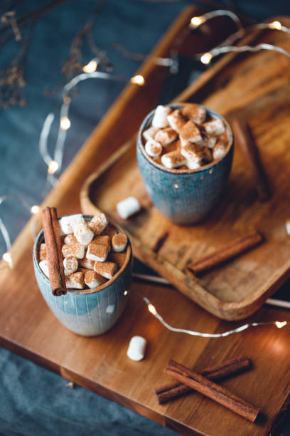 istock Hot chocolate with marshmallows and cinnamon in blue ceramic cups on a table. The concept of cozy holidays and New Year. 1257054934
