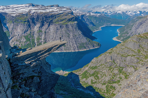 Trolltunga, Odda, Norway; July 16, 2020 - Young adult admiring the view from Trolltunga.