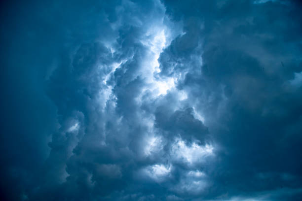 istock Dark background with ominous thunderclouds and rain pouring from the sky. Small raindrops when looking up. 1257059675