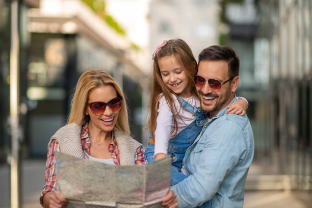 Happy young family of three smiling while spending time together stock photo