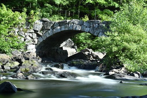 Beautiful stone arch bridge over river in New Hampshire.