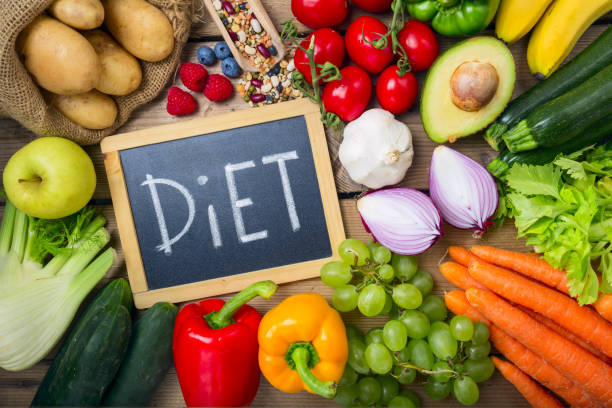 istock Black Chalk Board with DietTexts with Assorted Organic Veggies on Sides on Top of Wooden Table 1257062016