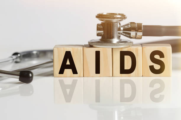istock AIDS the word on wooden cubes, cubes stand on a reflective white surface, on cubes - a stethoscope. 1257062956