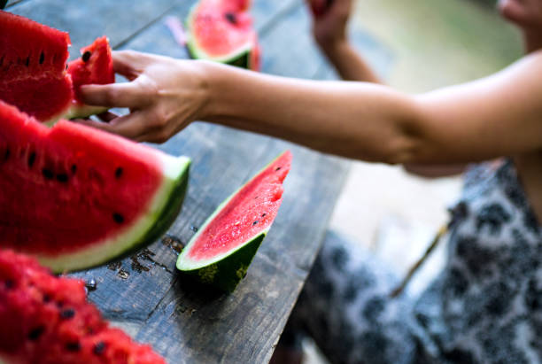 istock Woman cutting watermelon 1257063046