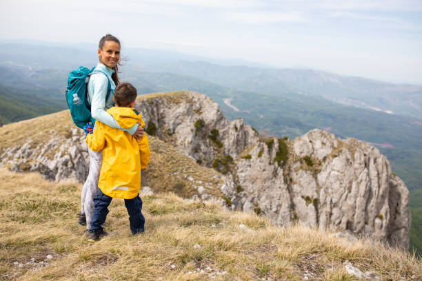 istock Mom and son hikers hugging on a cliff 1257064217