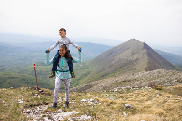 istock A boy getting a shoulder ride from his mom while on a hike in the mountains 1257064241