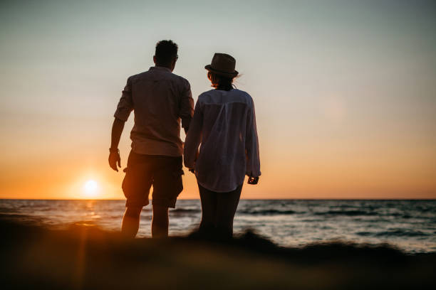 istock Happy loving young couple walking on the beach 1257067387
