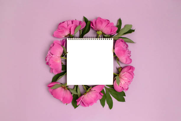 istock Empty notebook mockup with wreath made of peony flowers. 1257068261