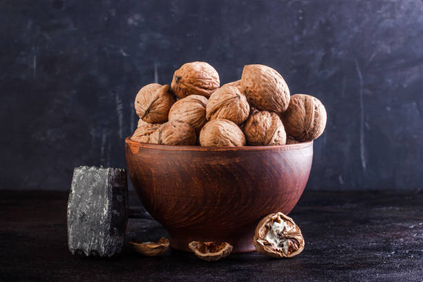 istock Walnut in a clay bowl, young and broken walnut 1257072167