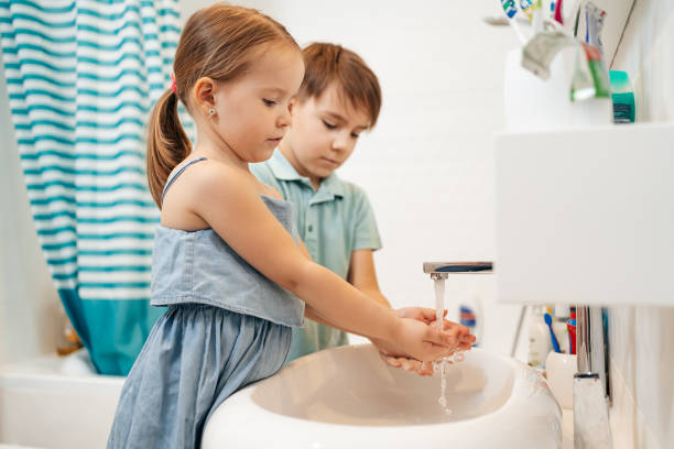 istock Brother and sister wash hands 1257072272