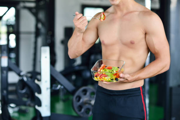istock Powerful athletic man with great physique eating a healthy salad. 1257077013