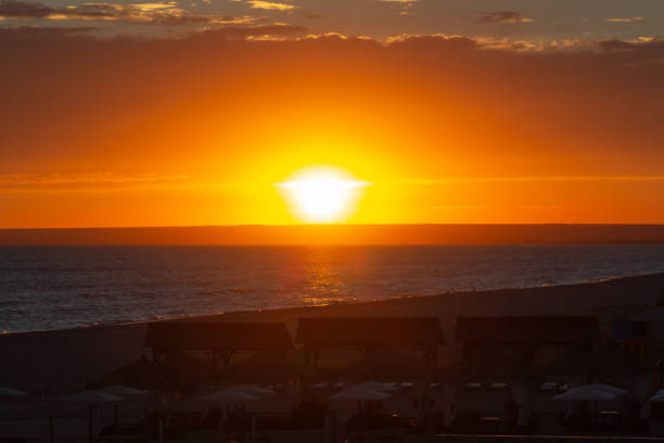 bright sunset over the sea beach with gazebos