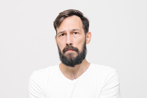 close-up portrait of sad young man in studio on white background. High quality photo