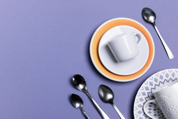 istock A stack of ceramic plates, espresso, coffee or tea cups with ornaments. A group of small teaspoons. Serving concept in pastel colors 1257079751