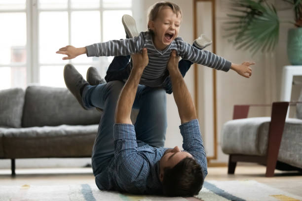 istock Laughing little boy pretending flying, playing with happy father 1257080796
