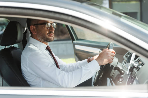 istock Side view of handsome businessman driving car 1257082536