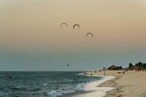 People at Barra Grande beach in Piauí, with kite surfers