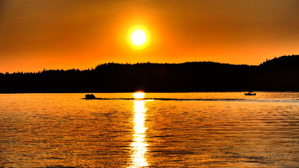 istock Sunset over river with silhouette of boats 1257084283
