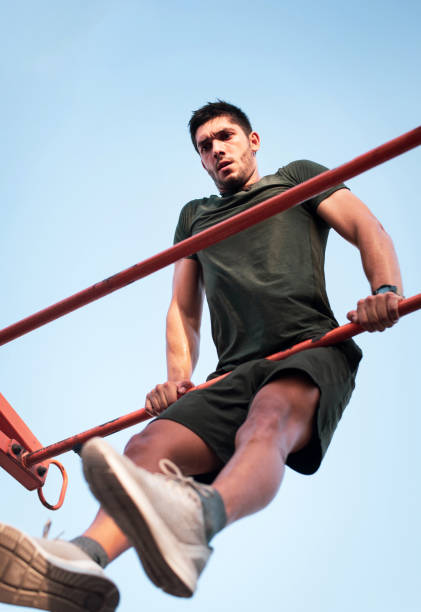 istock Strong man doing muscle-up advanced variation of pull ups on a bodyweight street workout 1257084679