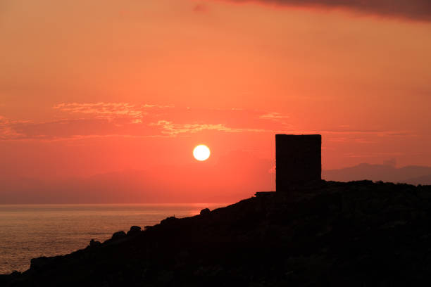 istock Sun rising behind genoese tower in Corsica 1257086617