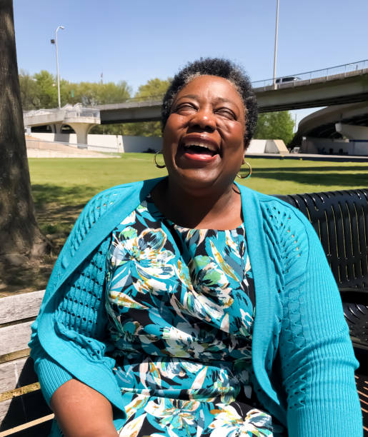 African American Woman Laughing in Park An African American woman enjoys a warm spring day in the park. michael dean shelton stock pictures, royalty-free photos & images