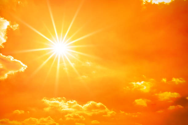 Glowing sun on orange sky Hot summer or heat wave background, orange sky with clouds and glowing sun sunlight stock pictures, royalty-free photos & images