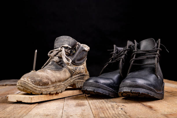 istock Old work shoe pierced with a nail. New work shoes. Dark background. 1257089870