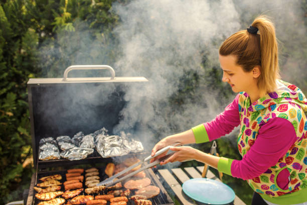 istock Woman At Barbecue In Backyard 1257092647