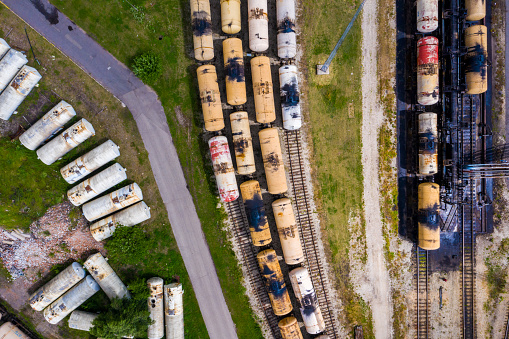 Top aerial view of cargo trains. Aerial view from flying drone of colorful freight trains on the railway station. Wagons with goods on railroad. Heavy industry.Industrial conceptual scene with trains.