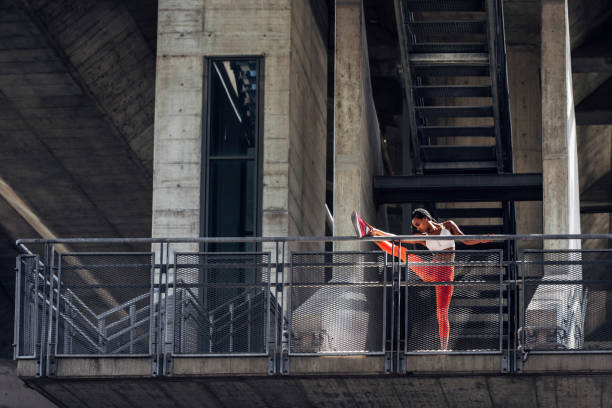 istock Urban Exercise: African Sportswoman Stretching her Leg 1257094166
