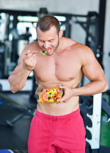 istock Powerful athletic man with great physique eating a healthy salad. 1257096370