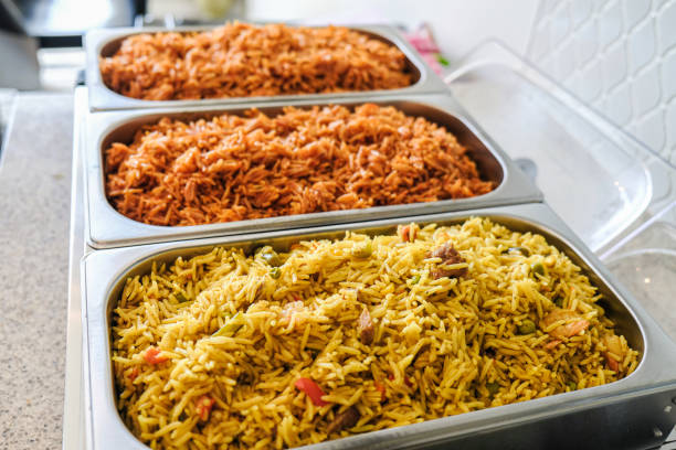 нигерийский jollof и овощной жареный рис подается в chaffing блюдо - canada rice стоковые фото и изображения