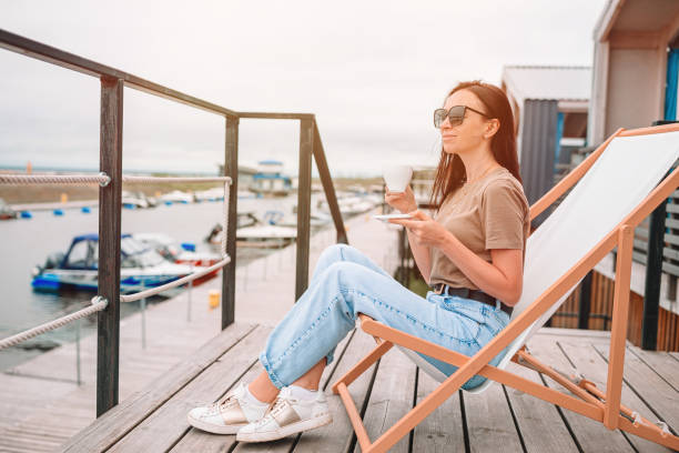 istock Young woman drinking hot coffee enjoying beach view. 1257097354