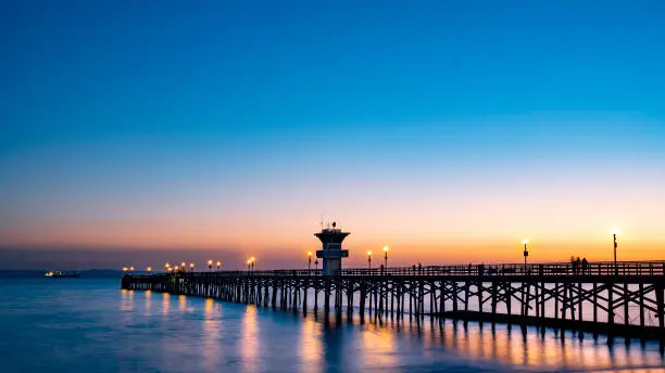 Beautiful Beach Pier at sunset; peaceful water and wooden bridge
