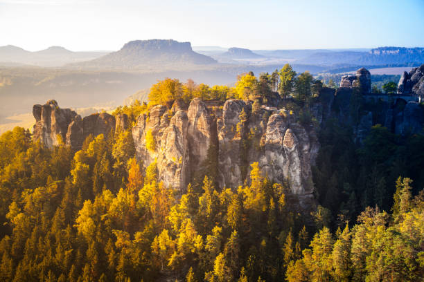 Sunrise at the Bastei bridge above the Elbe River in the Elbe Sandstone Mountains of Germany. One of the most spectacular hiking regions in Europe. The bizarre, primeval landscape of the Saxon Switzerland simply overwhelms visitors. colorido amanecer en el puente bastei sobre el río elba en las montañas de arenisca del elba de alemania. una de las regiones de senderismo más espectaculares de europa. el extraño paisaje primigenio de la suiza sajona simplemente abruma a los visitant