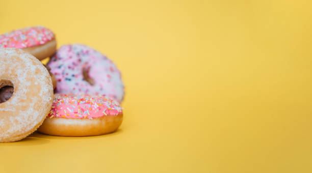 istock Variety of donuts on a yellow background and copy space 1257101277