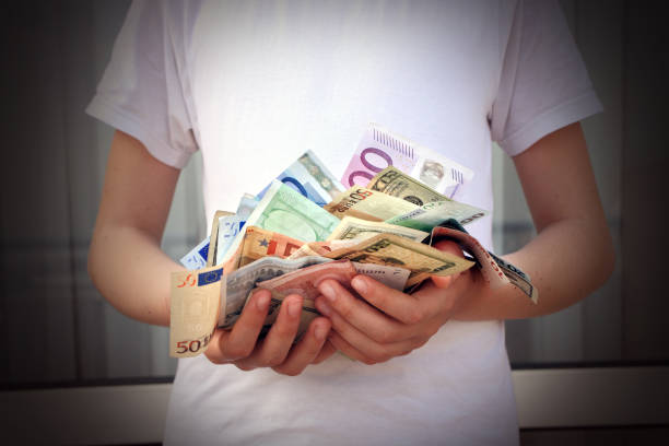 young man holding pile of various paper currency close up shot of male hands holding bunch of money depression behavior businessman economic depression stock pictures, royalty-free photos & images