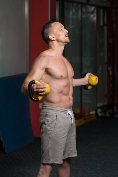 hombre muscular haciendo ejercicio con kettle-bell - kettle bell activity aerobics athlete fotografías e imágenes de stock