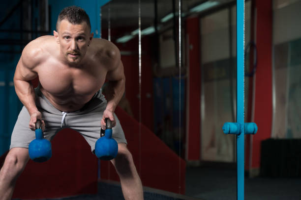 hombre muscular haciendo ejercicio con kettle-bell - kettle bell activity aerobics athlete fotografías e imágenes de stock