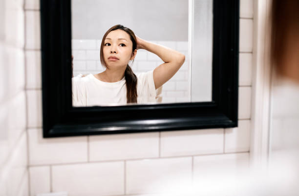 istock Asian Woman Using Mirror in the Bathroom 1257111845