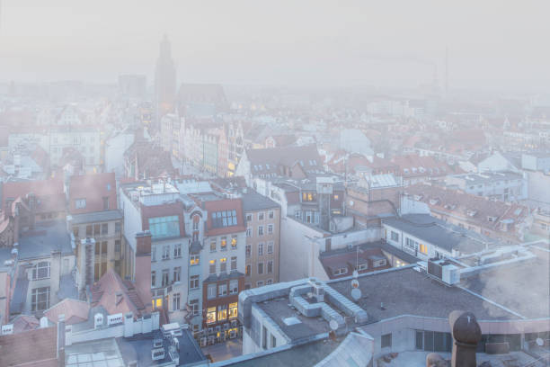 starker smog über der stadt im winter in breslau, polen. dicke schicht aus smog und dunst verdunkelt die ansicht. winteransicht der skyline der stadt, mit nebelpartikeln in der verschmutzten umwelt. - smog city pollution town stock-fotos und bilder