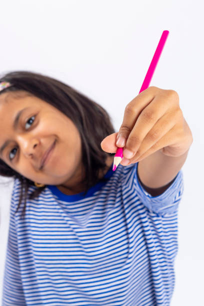 istock Cute left-handed girl is writing with a pencil in her notebook. 1257114378