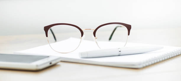 istock Close-up of glasses with a notebook on the table. Working space 1257117314