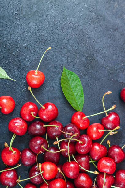 istock Cherry with leaf on plate and water dropsand on grey stone table 1257121147