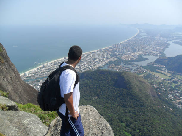 homme admirant le regard du haut de la pierre de gavea ( pedra da gavea ) à rio de janeiro - gavea mountain photos et images de collection