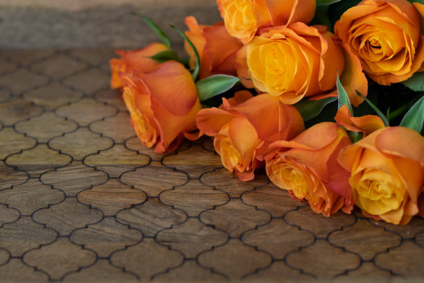 Bouquet of yellow(orange) roses on the wooden background