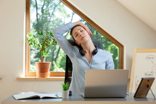 belles femmes exécutant des exercices et s’étirant devant un ordinateur portatif. travailler à la maison, concept de santé. - yoga business women indoors photos et images de collection